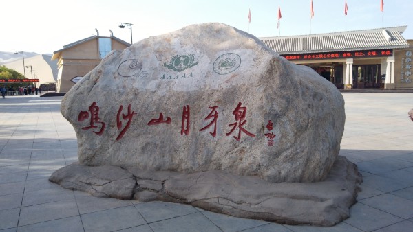 一早起来赶去看库木塔格大沙漠,就在鄯善县城南,紧挨着县城。这个沙漠很有代表性,有沙丘,有沙山。沙粒很细,呈黄褐色。试着走上沙丘,感觉蛮有意思,沙子软软的,走一步陷一步留下的不是脚印而是脚坑,最松软的是沙坡的沙子,相对硬实点的是沙丘脊。很多人脱了鞋子走上去,不一会就被热沙子烫得赶紧把鞋穿上。还有更多的女士披上各色纱巾摆出各种姿势尽情的照相留念。从沙漠回到景区门口,碰到一伙山东游客在一个卖玉石的小摊前买玉镯,我刚走到近前想凑个热闹,忽然听见身为摊主的维族大姑娘对他们一边摆手一边用维族普通话(简称:维普)大叫